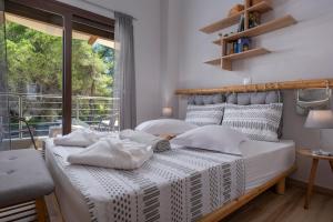 una camera da letto con un letto con lenzuola bianche e una finestra di Limoncello Villas a Vourvourou