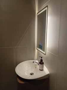 ein Badezimmer mit einem weißen Waschbecken und einem Spiegel in der Unterkunft Jazotel Batam in Jodoh + 11 Fotos