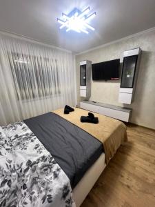 a bedroom with a large bed and a chandelier at Tilia Appartment in Craiova