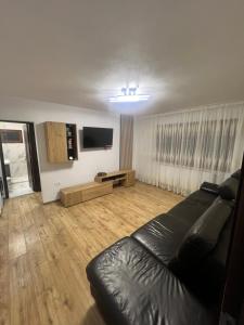 a living room with a couch and a flat screen tv at Tilia Appartment in Craiova