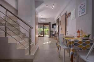 una sala da pranzo con un tavolo e una scala di Limoncello Villas a Vourvourou