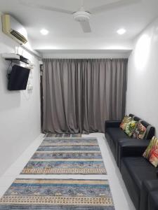 a living room with a couch and a television at Alfateh Homestay in Sungai Petani