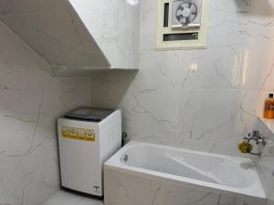 New cairoرويال شقة بالتجمع الخامس امتداد الجامعة الامريكية的白色的浴室设有水槽和浴缸。