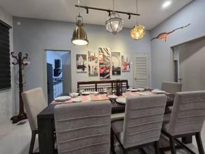 a dining room with a table and chairs at TropINN LoDonHeartBeat 5LuxRoom CirPool BBQ & KTVFun in Bandar Penawar +34 photos