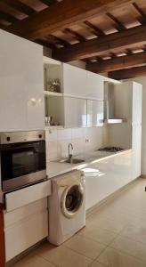 een keuken met een wasmachine en een wastafel bij Fattoria Adriatica in Porto SantʼElpidio