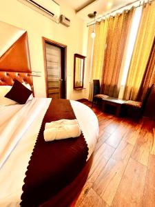 钱德加尔Hotel WoodCrest Chandigarh Zirakpur的房间里有一张大床的卧室