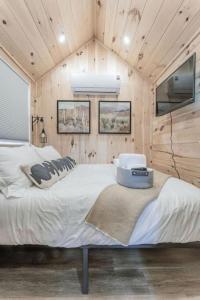 a bedroom with a large bed in a wooden wall at Charming Micro Home Escape: Unforgettable Glamping Experience in Colorado in Grand Junction +7 photos