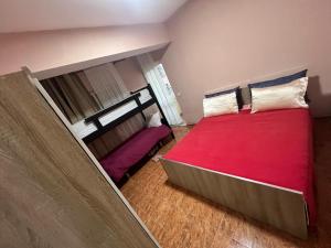a bedroom with a large bed with a red blanket at Open Door Hostel in Tirana +26 photos