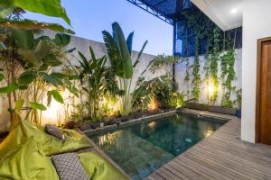 an indoor pool in a house with plants at Tiny Villa Bali Jimbaran in Jimbaran