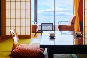 a table and chairs with two cups on top of it at Seaside Hotel Mimatsu Ooetei in Beppu