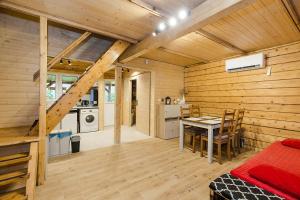 a wooden cabin with a table and a kitchen at Całoroczny, drewniany domek przy lesie in Prażmów +27 photos