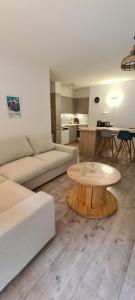 a living room with a couch and a table at Appartement proche remontées refait à neuf in Crans-Montana
