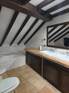 ein Badezimmer mit zwei Waschbecken und einer Badewanne und einer Toilette in der Unterkunft Casona Arquillo del Judío in Toledo