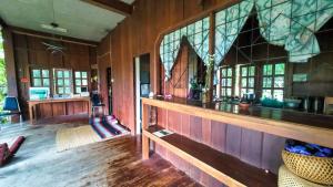 a room with wood paneling and a wall with windows at Babazia Community in Pai