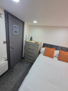 - une chambre avec 2 lits blancs et une porte dans l'établissement The Orange Outpost - Modern Studio Near Alhambra, à Bradford
