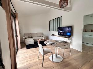 a small living room with a table and a television at Un toit pour 2 in Le May-sur-Èvre