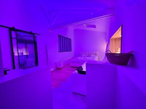a purple room with a couch and a table at Un toit pour 2 in Le May-sur-Èvre