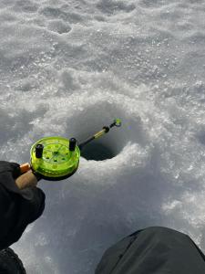 MelkoniemiTarula Holiday Home的雪地里有人拿着一个绿色装置。