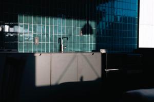 a kitchen with a sink and blue tiled walls at TATARA FACTORY stay in Imabari