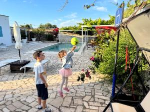 a boy and a girl playing with a tennis ball at La Corte di Nunu' in Monopoli +21 photos