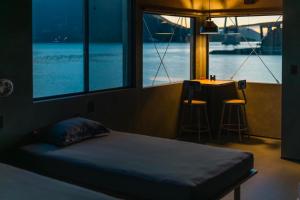 a bedroom with a bed and a table and windows at TATARA FACTORY stay in Imabari