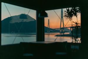 a view of a sunset through a window of a boat at TATARA FACTORY stay in Imabari