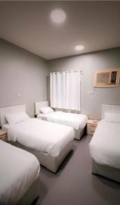 a room with four beds and a window at شقة الخالدية 3 in Al Madinah