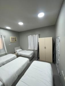 a room with three beds and a cabinet at شقة الخالدية 3 in Al Madinah +9 photos