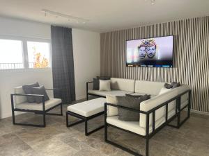 una sala de estar con un sofá y dos sillas en Renovated APT with panoramic view, en Cully