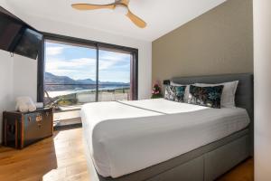 a bedroom with a large bed and a large window at Les Restanques du lac in La Chapelle