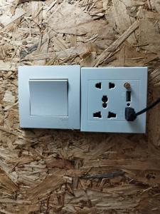 a white electrical outlet with a cord plugged into it at Sleepbox Hotel in Cameron Highlands