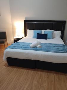 a bedroom with a large bed with blue and white pillows at Jerilderie Hotel in Jerilderie