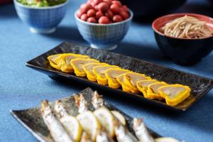 una mesa con dos platos de comida y tazones de fideos en Hotel Vista Kumamoto Airport, en Ozu