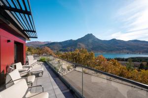 a balcony with white chairs and a view of a lake at Les Restanques du lac in La Chapelle