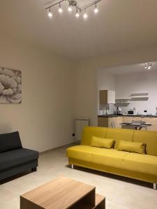 a living room with a yellow couch and a kitchen at Ma Home in Cinisi +17 photos