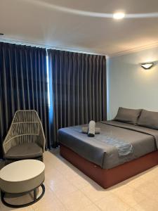 a bedroom with a bed and a chair and a table at Neela House in Labuan +12 photos