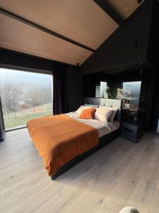 a bedroom with a large bed and a large window at Nordic Star Chalet in Fundata +33 photos