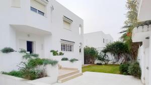 ein weißes Haus mit einem Innenhof mit Pflanzen in der Unterkunft Villa Souad - havre de paix et charme tunisien aux portes de Tunis in La Marsa