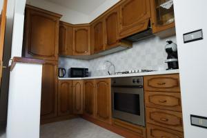 - une cuisine avec des placards en bois et un four dans l'établissement L Agrifoglio di Rita Loddo, à Fonni 30 autres photos
