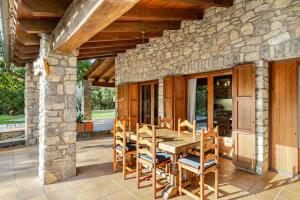 ein Holztisch und Stühle auf einer Terrasse in der Unterkunft El Vilarot. La casa de piedra en la naturaleza. in Girona