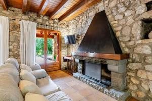 ein Wohnzimmer mit einer Steinmauer und einem Kamin in der Unterkunft El Vilarot. La casa de piedra en la naturaleza. in Girona