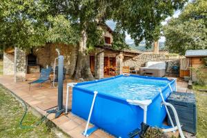 einem blauen Pool vor einem Haus in der Unterkunft El Vilarot. La casa de piedra en la naturaleza. in Girona
