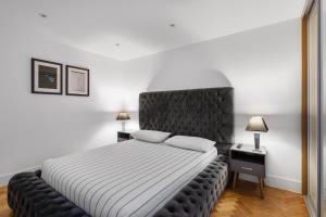 a bedroom with a large bed with a black headboard at Chelmsford Town Centre, Modern 1 Bed Apartment in Chelmsford