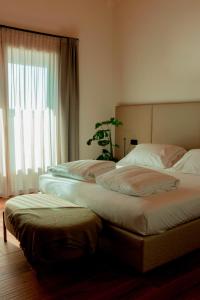 zwei Betten in einem Hotelzimmer mit Fenster in der Unterkunft Tenuta Tommasi - Relais Bacco in Caorle