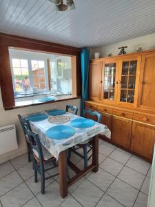 a kitchen with a table and some chairs and a window at Cottage Le pêcheur du Grand Large proximité plage in Asnelles +7 photos