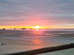 einen Sonnenuntergang am Strand mit Sonnenuntergang in der Unterkunft Cottage Le pêcheur du Grand Large proximité plage in Asnelles + 7 Fotos