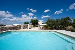 a swimming pool in front of a villa at Borgo SantaMarta in Noci