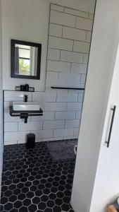 a bathroom with a sink and a mirror at Modern Sea and Mountain View Apartment - Gordon's Bay in Gordonʼs Bay +8 photos