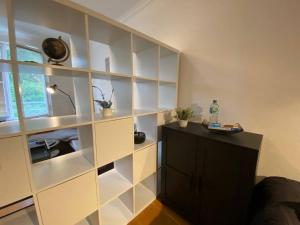 a room with white shelves and a desk with a lamp at Cozy Apartment in Spandau Rauchstr with Garden View in Berlin