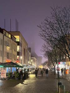 a group of people walking down a street at night at Cozy Apartment in Spandau Rauchstr with Garden View in Berlin